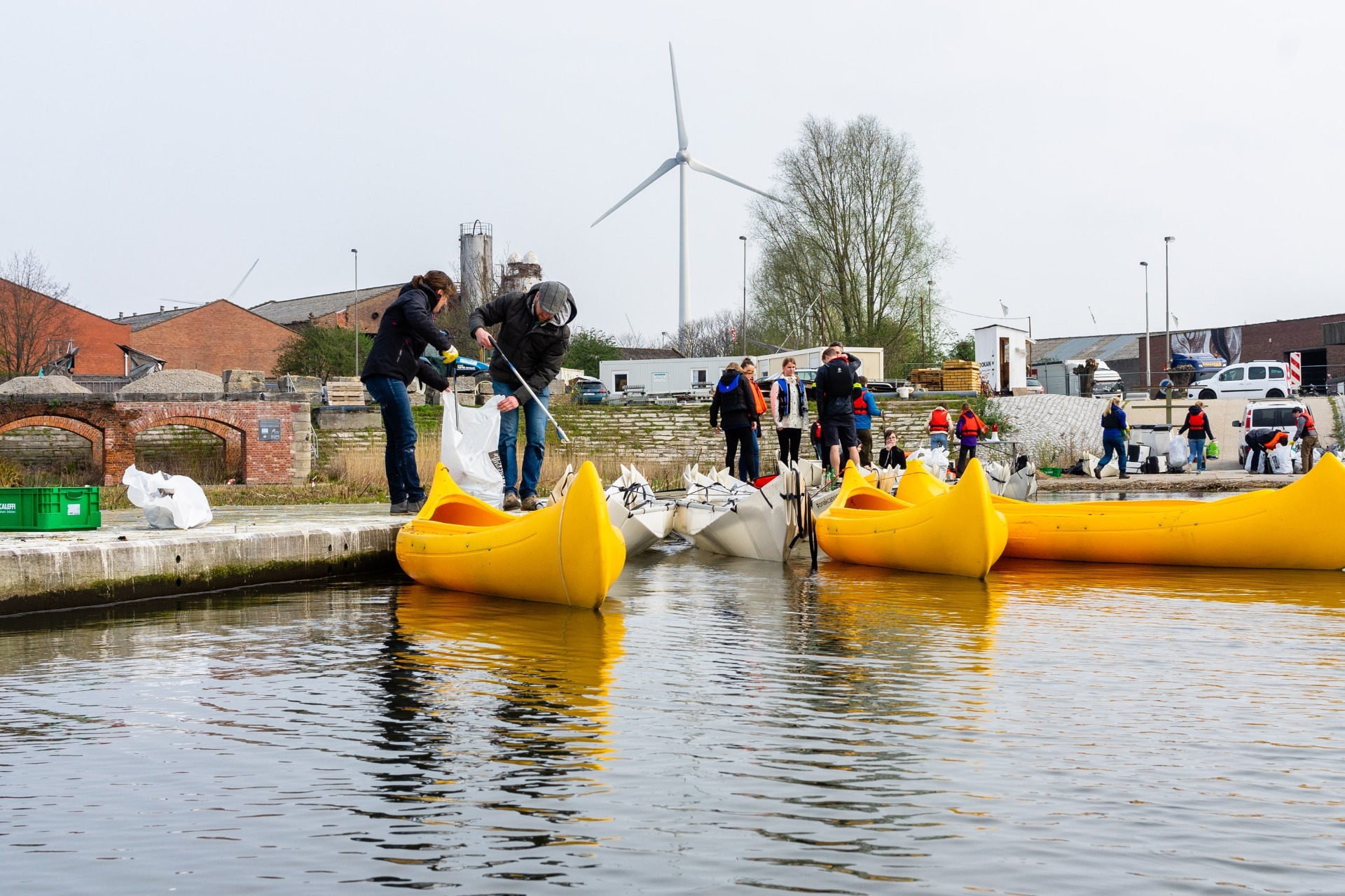 people setting garbage in the canoe